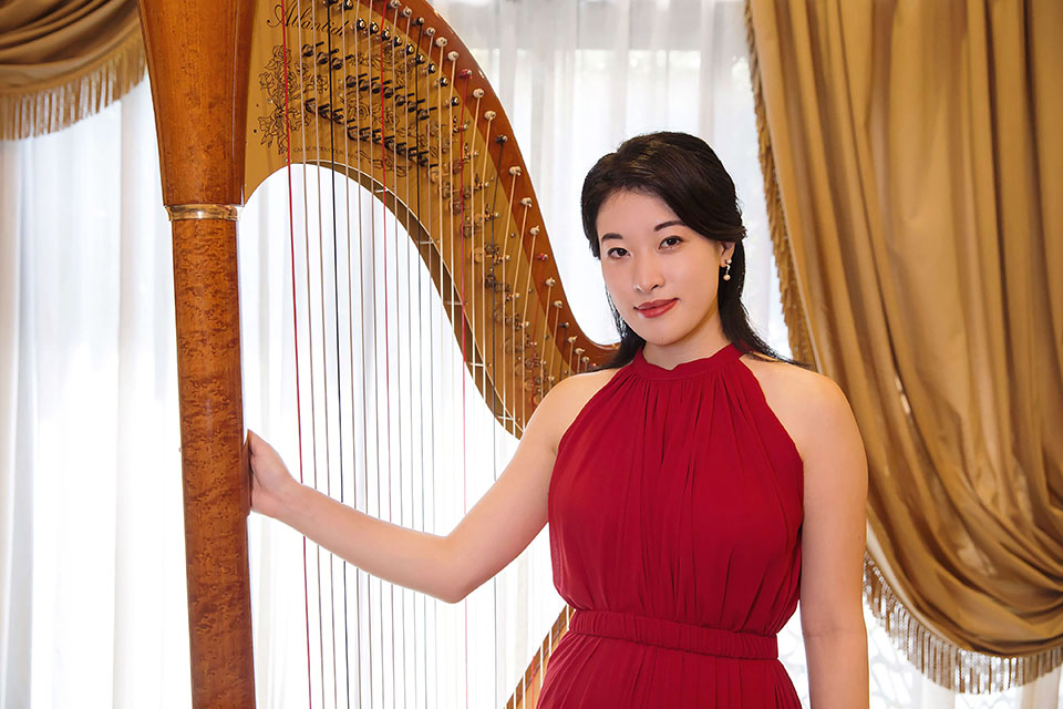 Laura stood in front of a harp